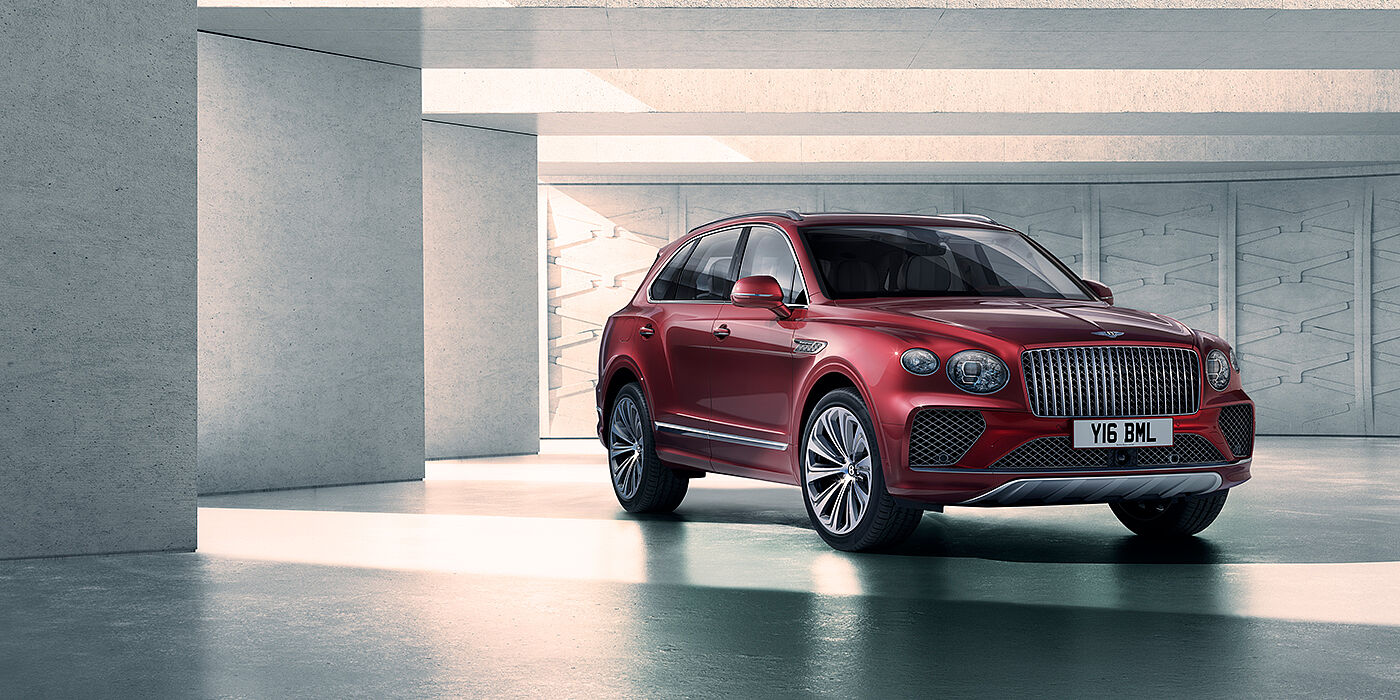 Bentley San Juan Bentley Bentayga Atelier Edition SUV in Rubino Red paint front three quarter against textured concrete wall