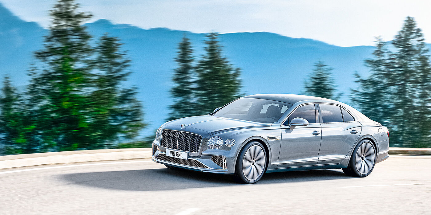 Bentley San Juan New Bentley Flying Spur sedan side view in Silverlake paint with ten spoke wheels and chrome matrix grille driving dynamically on a mountain road